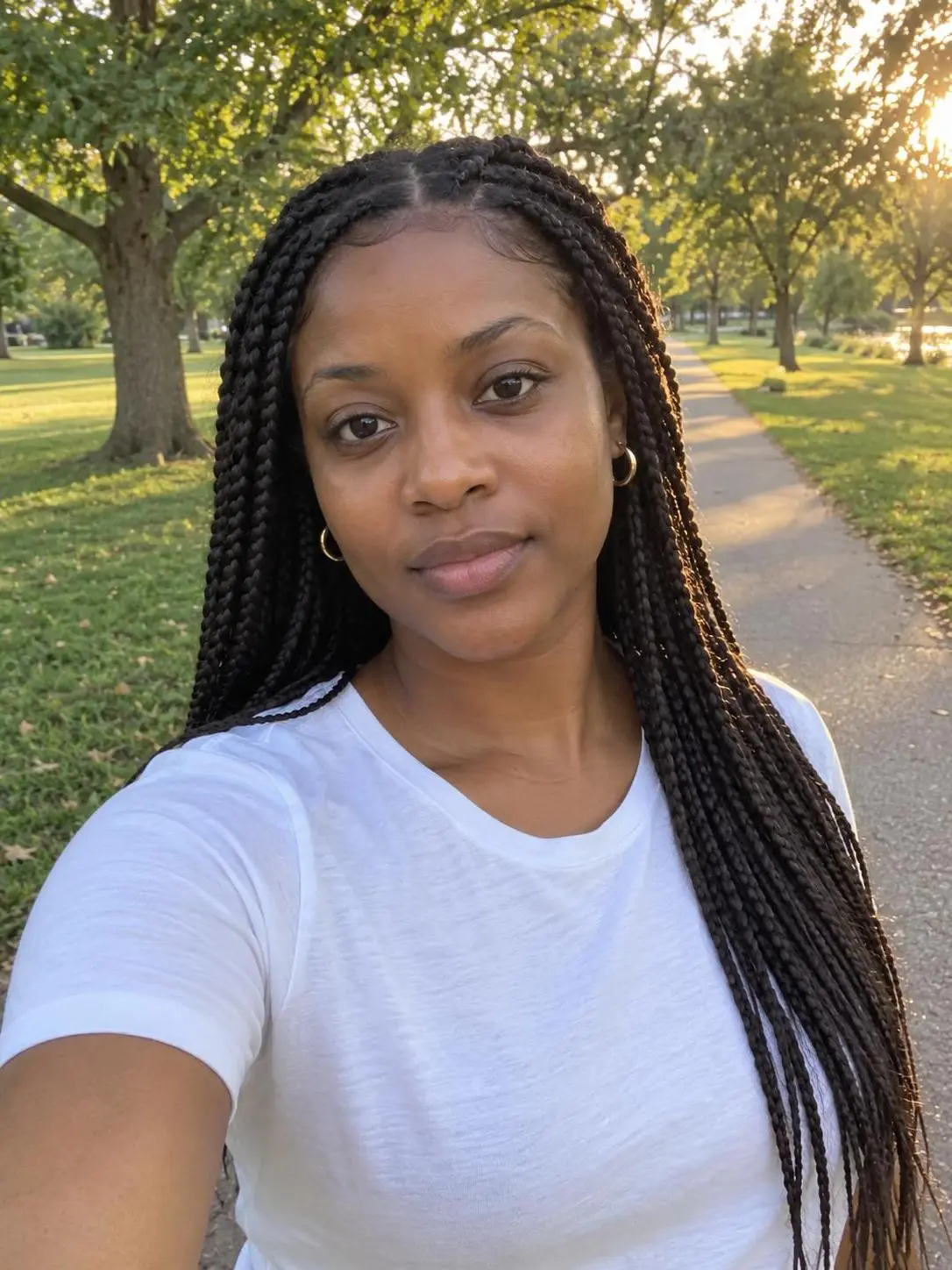 Generated phone-style source photo of a fictional woman on a park path (display-only sample).